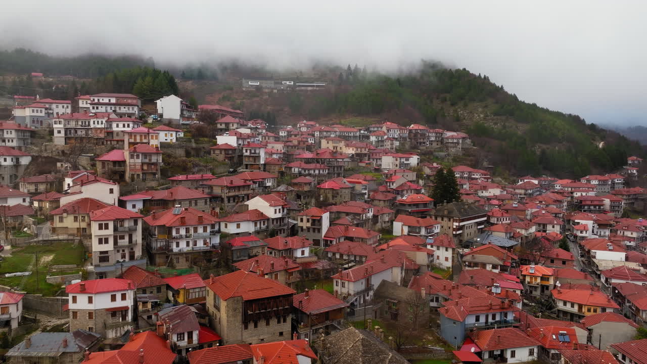 Epir, Yunanistan'da bir dağ yamacında, kırmızı kiremit çatılı Metsovo köy evleri, orta mesafeden havadan geri çekilme.
