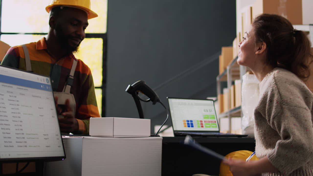 Warehouse employees working on computers and managing inventory