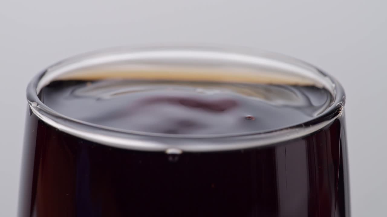 바탕에 신선한 콜라 한 잔에 떨어지는 얼음 큐브의 가까운