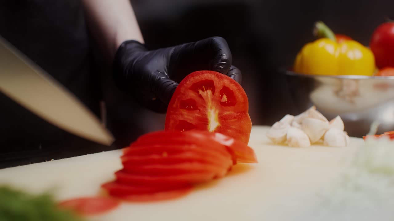셰프가 토마토를 잘라내고 있습니다.