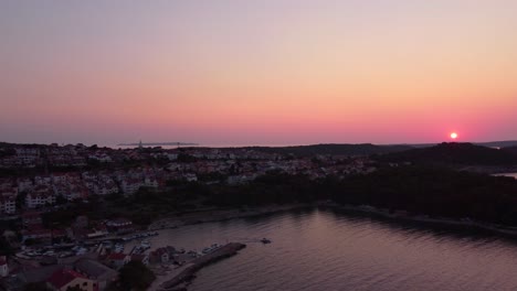 Volando-Sobre-La-Isla-Croata-Mali-Losinj-Y-Su-Ciudad,-Revelando-Una-Colorida-Puesta-De-Sol