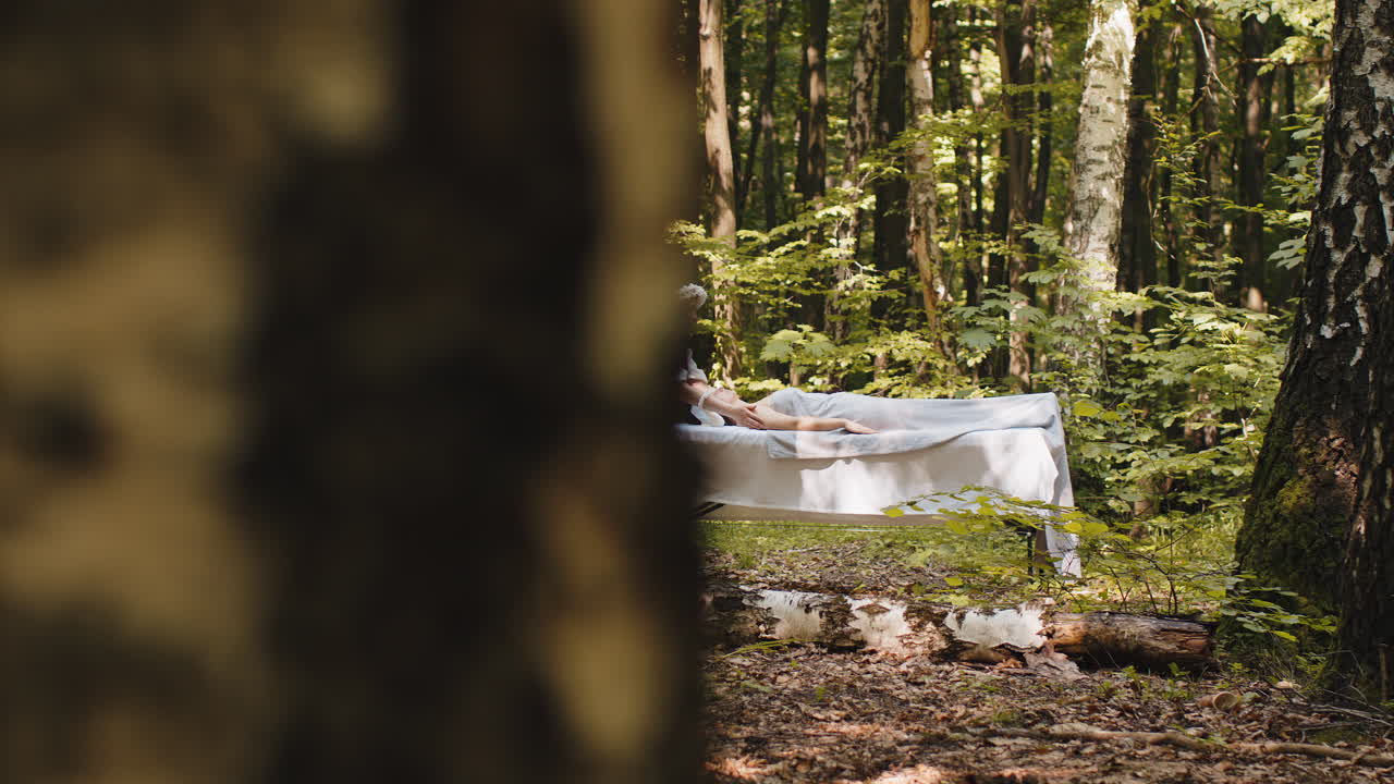 치료사 여성 의사는 숲에서 야외에서 손으로 스파 얼굴 마사지를하는 여성을 편안하게 만니다.