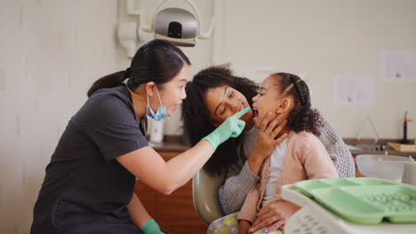 Dentist-checking-a-young-girl's-teeth-during