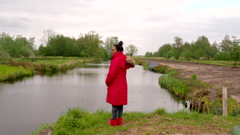 An-Indian-female-enjoying-nature,-canal-and-wildlife-in-the-Netherlands