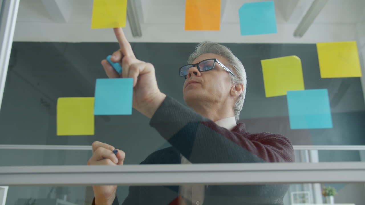 Business meeting using sticky notes on glass wall