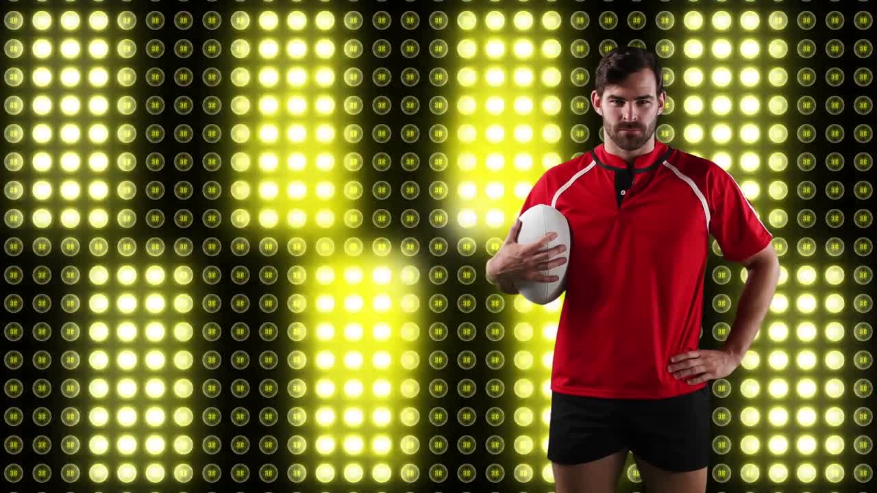 jugador de rugby profesional sosteniendo una pelota frente a una pantalla digital
