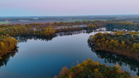dusk over calm dutch fields. vibrant trees line calm waterways in the netherlands during twilight, capturing the tranquil beauty of european nature