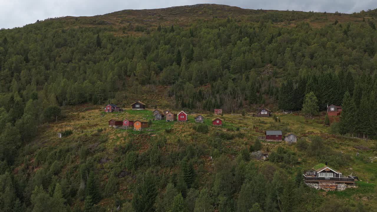 Rustikke hytter på grønn fjellside i naturskjønne Rakssetra, Norge