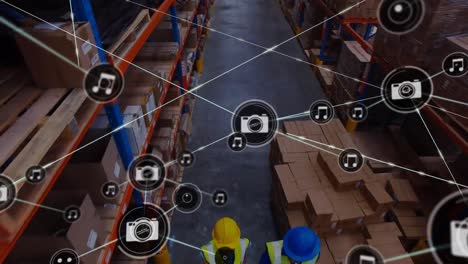 animation of network of digital icons against aerial view of workers working at warehouse