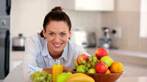 Bonita-Morena-Sonriendo-A-La-Cámara-Detrás-De-La-Fruta