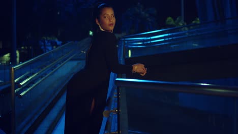 Young-hispanic-woman-enjoying-the-city-at-night-in-a-black-dress