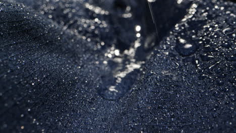 waterproof clothing for tourism. blue cloth texture with water drop close-up macro. repellent waterproof breathable fabrics. innovation waterproofing material test. high quality 4k footage