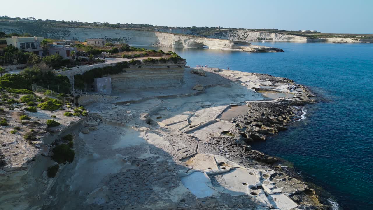 Aerial view along rocky beach on Maltese coastline near St. Peter's Pool