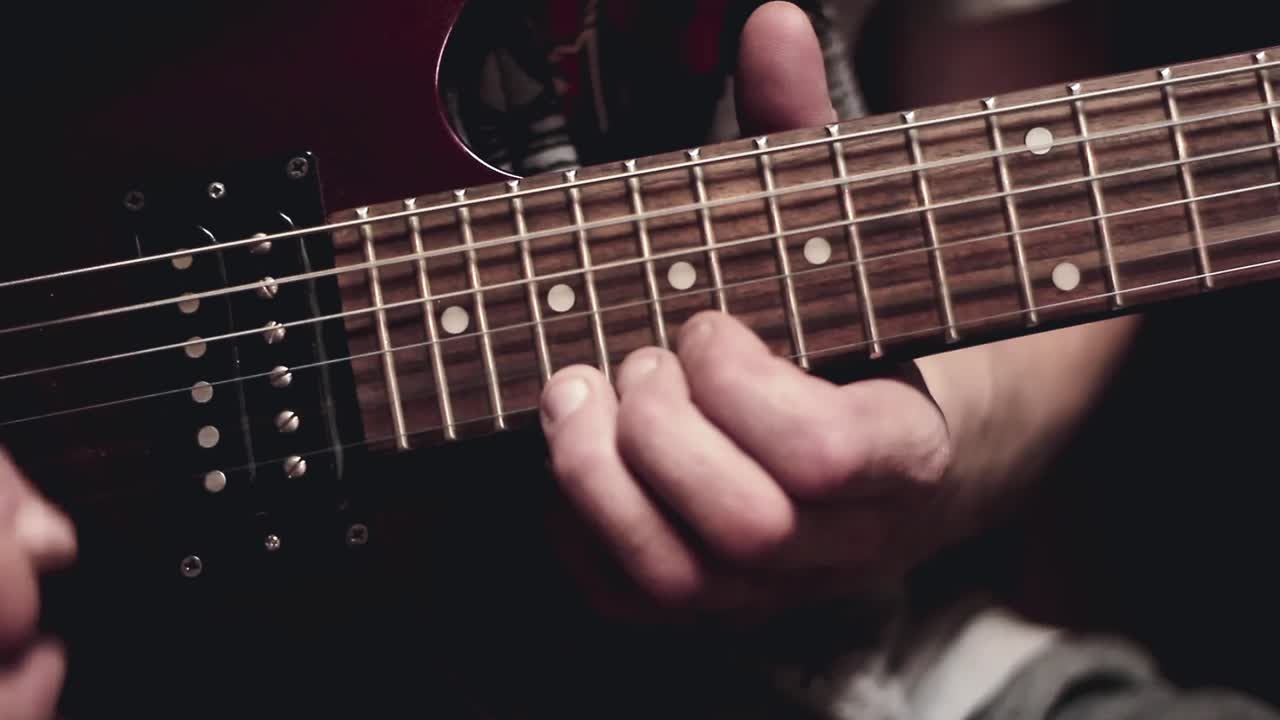 uomini che suonano la chitarra in un video d'archivio di una rock band