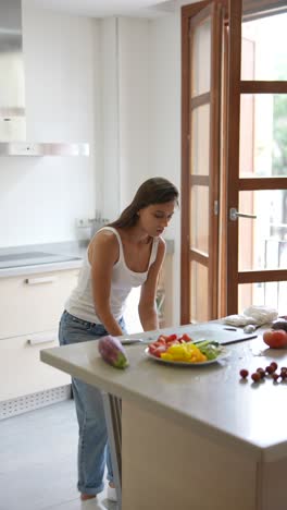 woman preparing a fresh fruit and vegetable salad in a modern kitchen