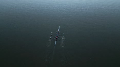 Drohnenaufnahme-Von-Vier-Ruderbooten,-Die-Schnell-Den-Fluss-Hinunter-Segeln