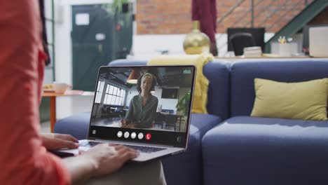 Mujer-Birracial-Usando-Una-Computadora-Portátil-Para-Videollamada,-Con-Un-Colega-De-Negocios-En-La-Pantalla