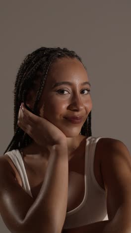 studio beauty shot of young woman with long braided hair sitting at table 7