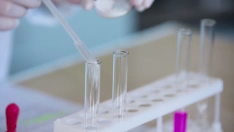 scientist performing a lab experiment with test tubes