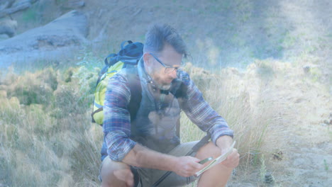 mature hiker crouching in meadow checking map with backpack while animated tech route line growing