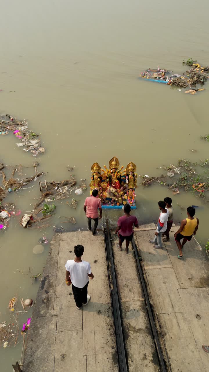 Drone view of immersion of idol of Hindu Goddess Durga in ganga river, garbage polluting river water
