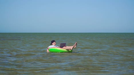 a young business person is enthusiastically working behind a laptop swaying on the waves of sea