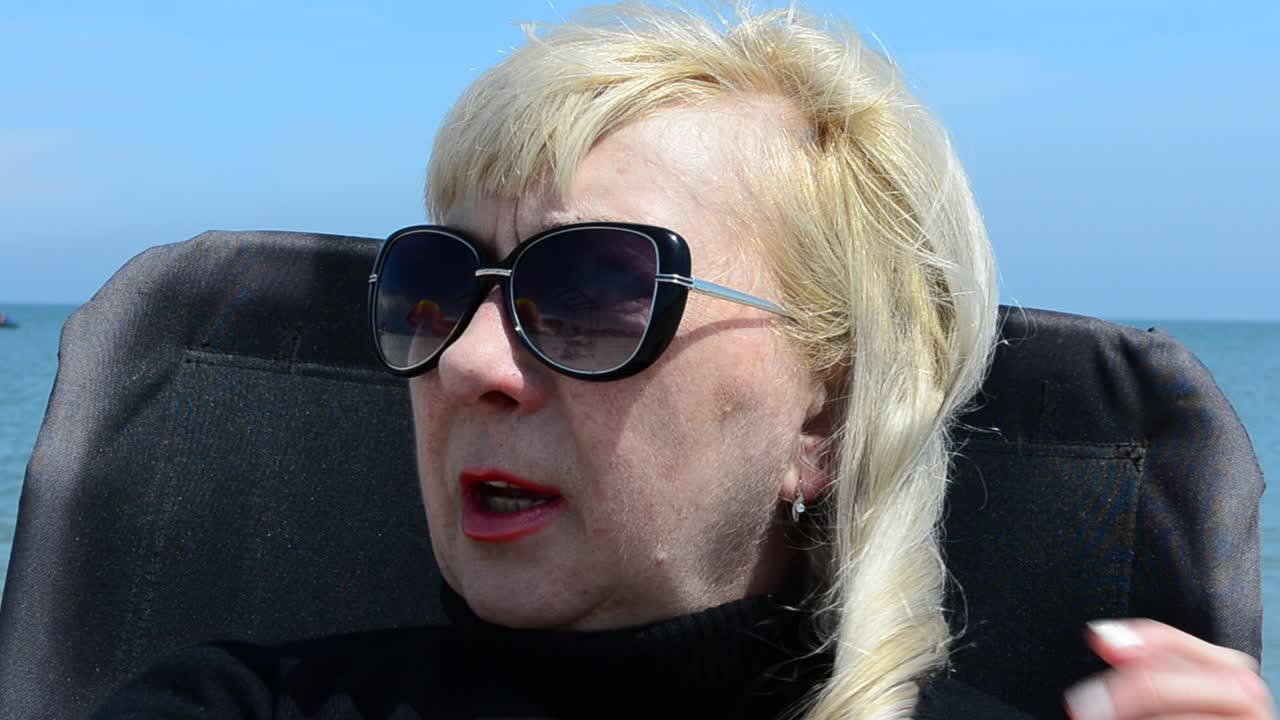 Donna con occhiali. Sedia e mare, donna.
