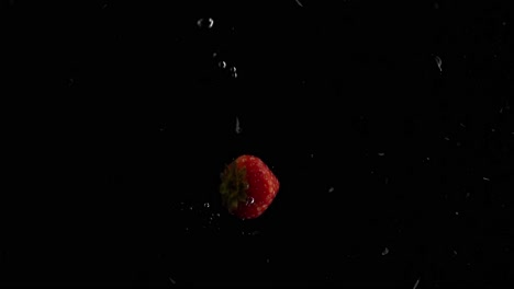 strawberry falling into water super slowmotion, black background, lots of air bubbles, 4k240fps