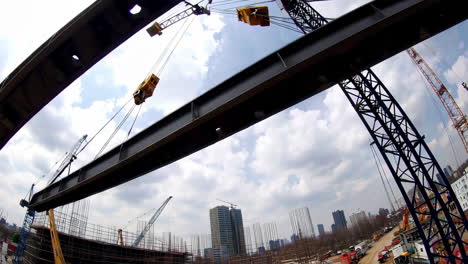 construction crane lifting steel beams on a high-rise building site