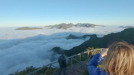 una mujer disfruta de la vista desde un punto de vista panorámico en las montañas durante el amanecer