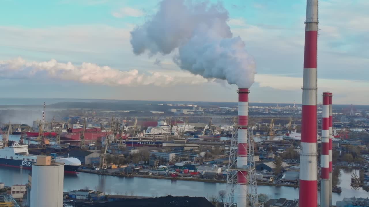 Smoke rises from industrial chimneys in Gdansk, Poland during daylight