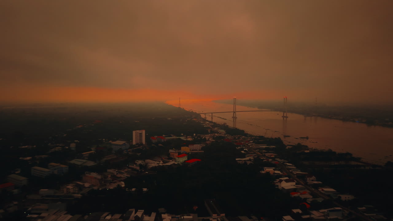 Aerial shot of Western Vietnam showing a river, bridges, and urban landscape at sunset