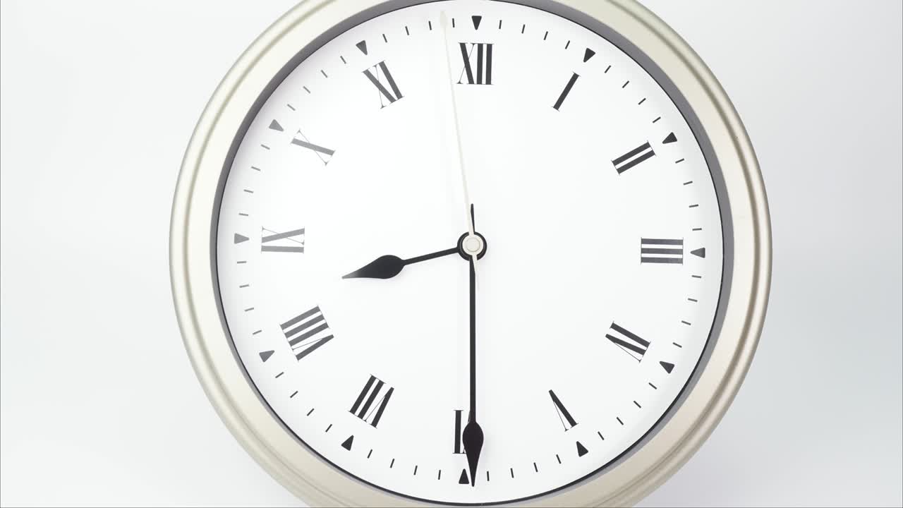 el reloj de pared de plata indica la hora a las nueve.