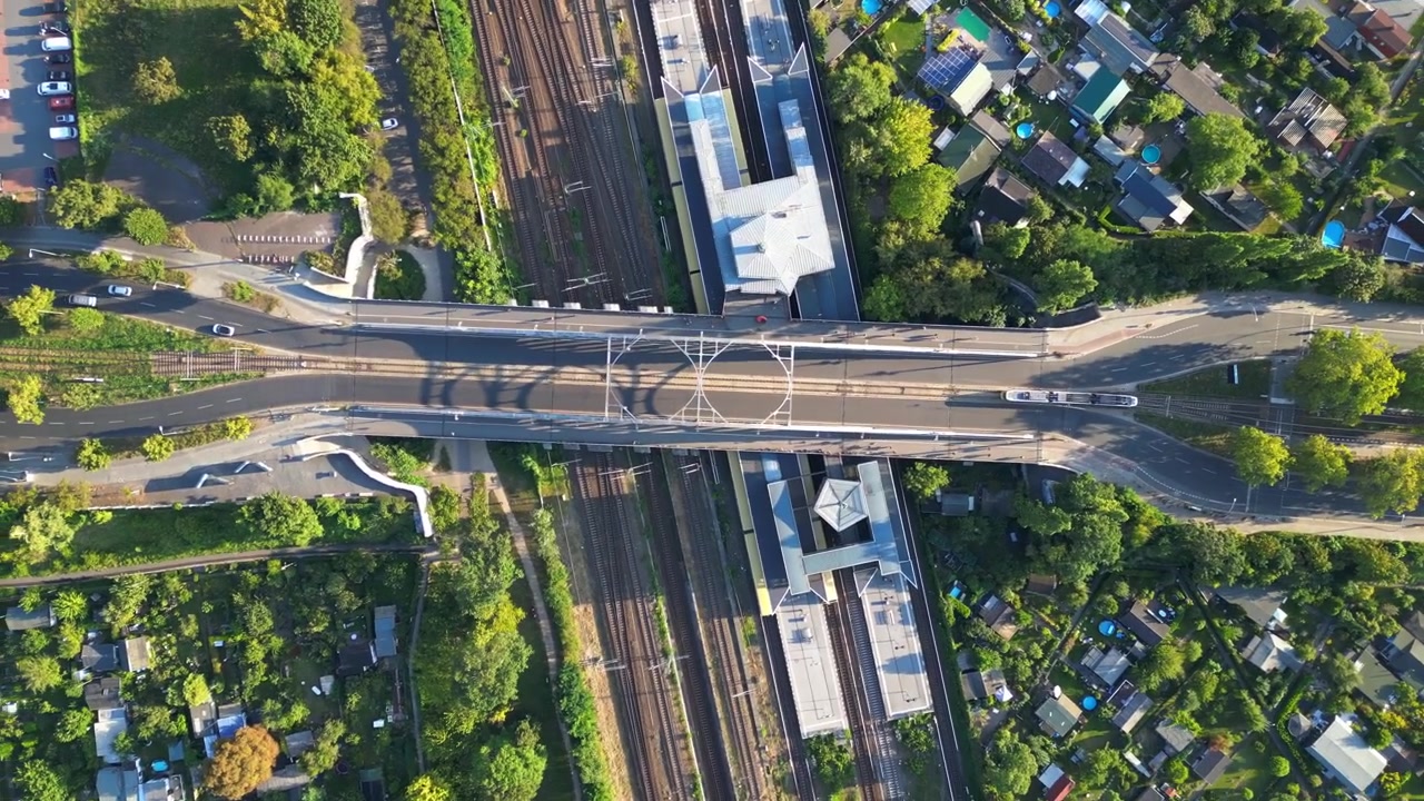 Trem berjalan di rel di Jembatan Agen Jalan Bornholmer di Berlin, Jerman pada hari musim panas yang cerah. Pemandangan udara vertikal menakjubkan dari drone.
