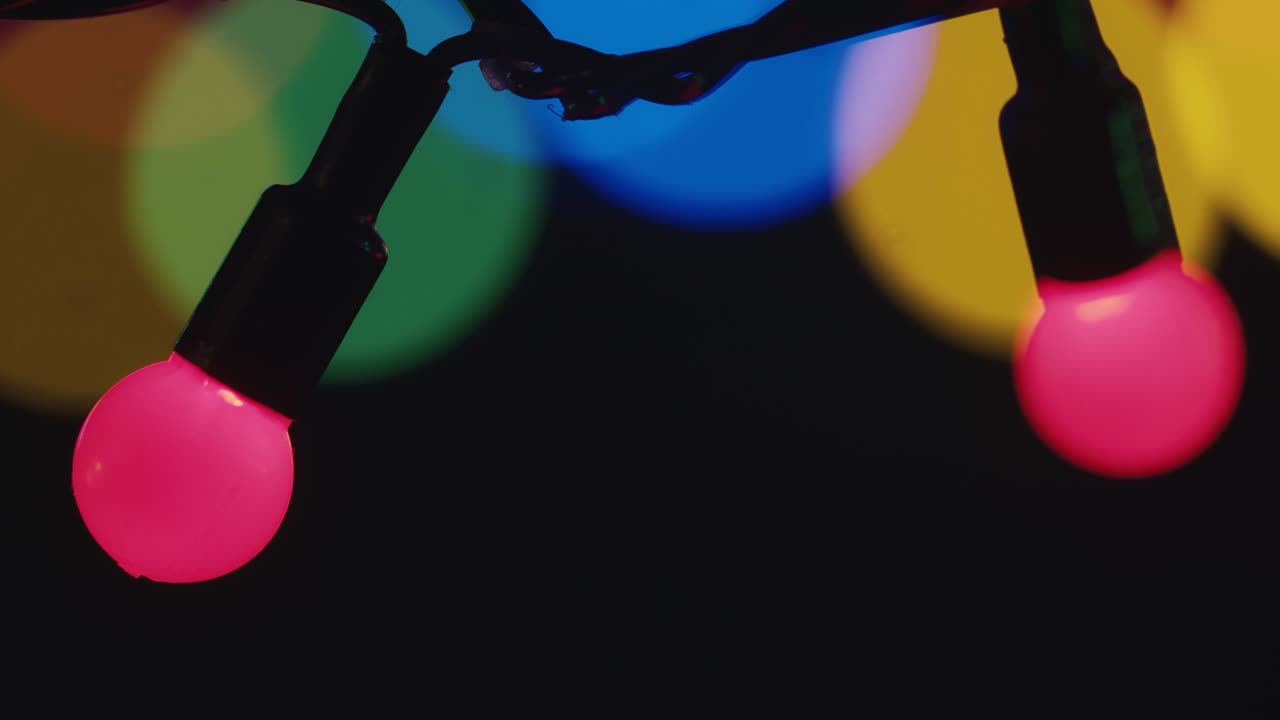 Close-up Of The Multicolor Blinking Christmas Lights garland on dark Background