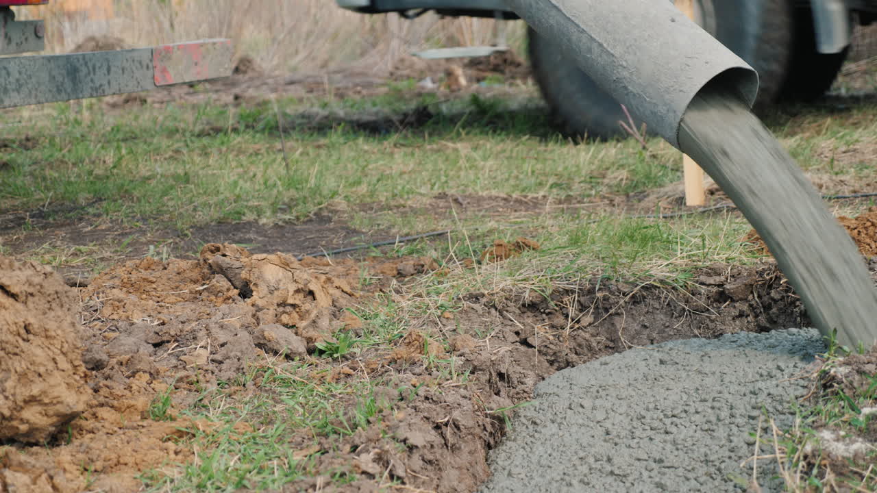 el hormigón fluye a través de la tubería hacia los cimientos del concepto de construcción de cabañas en el sótano
