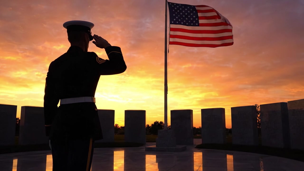 Un Saluto Solenne: Un Membro del Servizio Onora la Bandiera Americana all'Alba con uno Sfondo Mozzafiato di un Cielo Vibrante e un'Ambientazione Commemorativa Pacifica