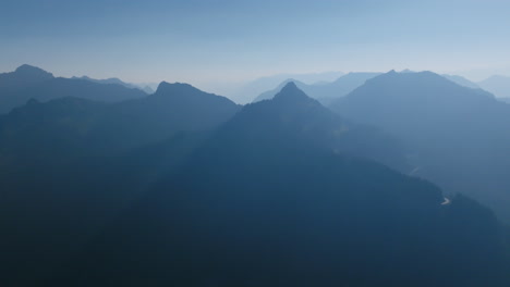 Aerial-footage-of-the-Cascade-Mountains-around-Mount-Rainier-in-silhouette-in-the-morning-haze