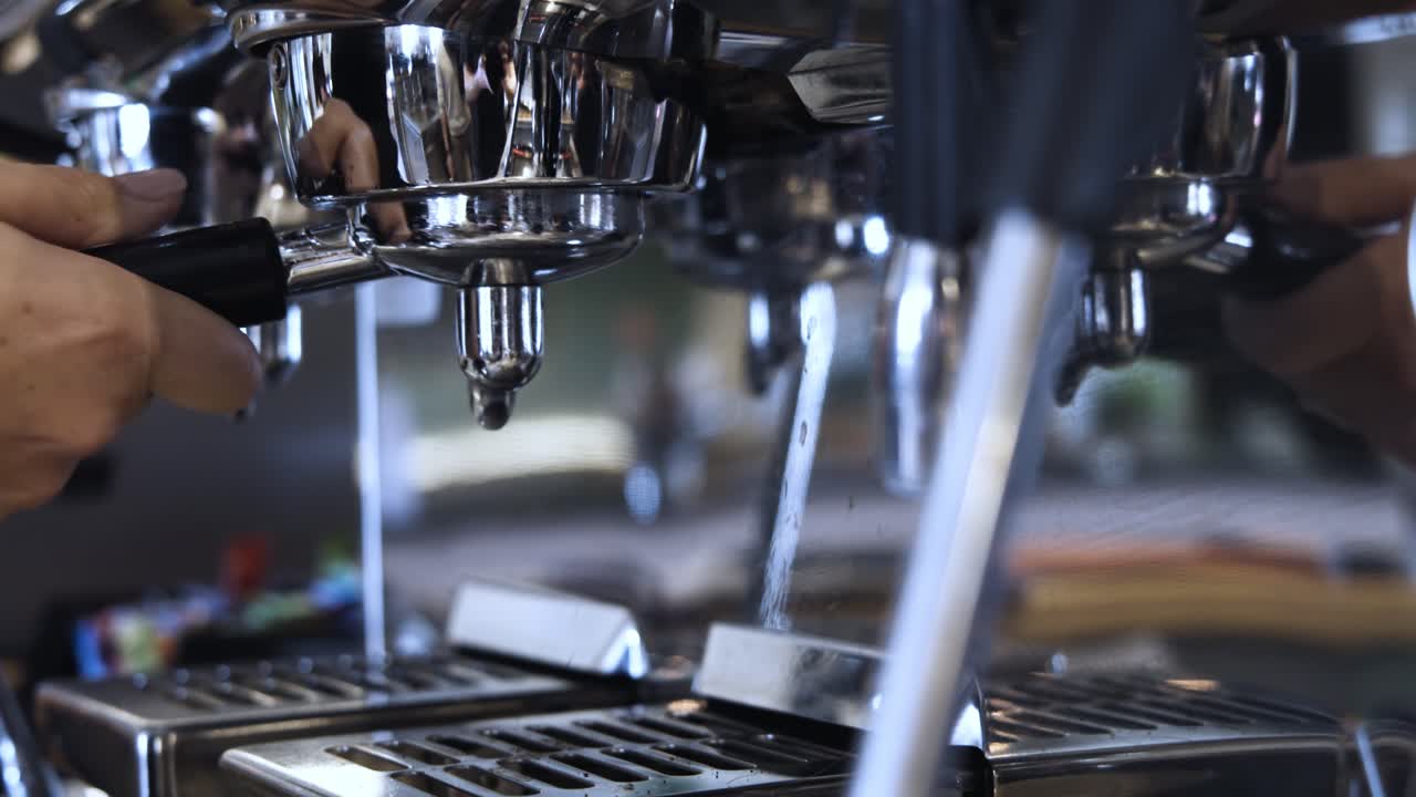 detalle en cámara lenta del barista preparando la máquina de café para la elaboración de la cerveza