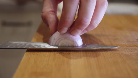 Slicing-onion-with-sharp-knife-on-a-cut-board