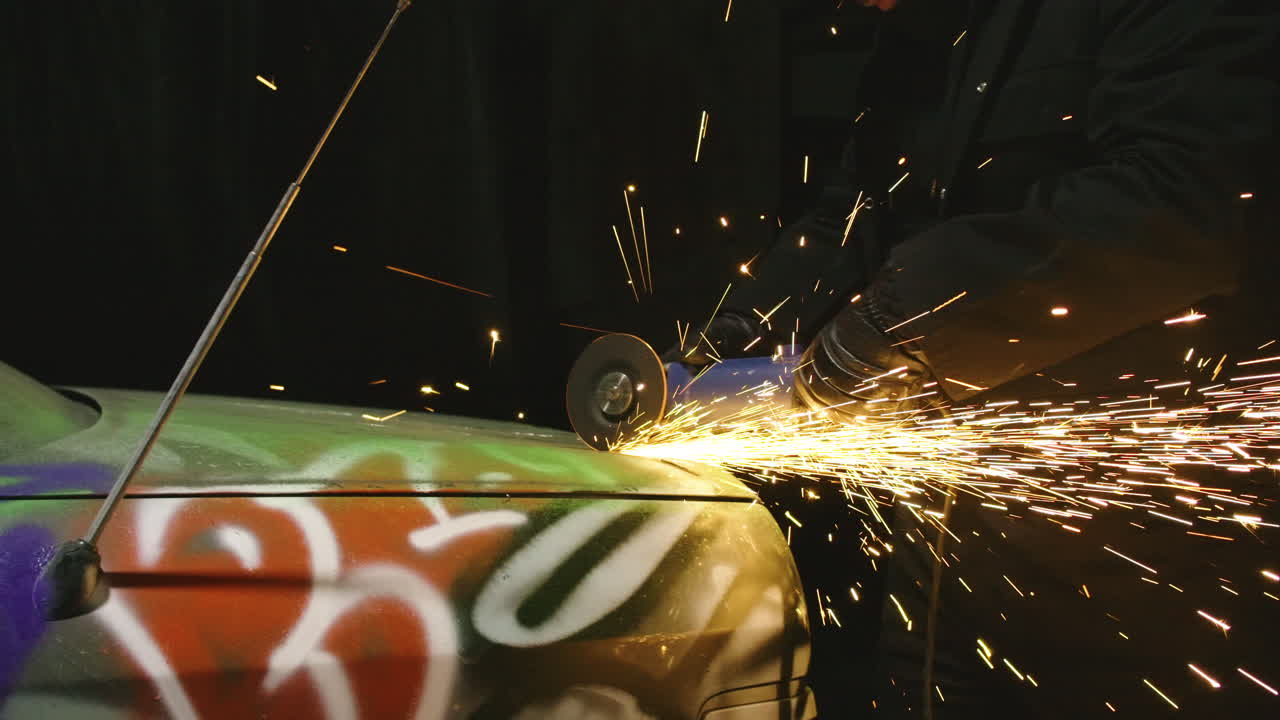 Dismantle junk mercedes car trunk with spinning grinder power tool, sparks in slow motion