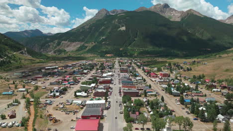 Aerial-cinematic-drone-summer-morning-downtown-Silverton-Main-Street-southern-Colorado-Red-Mountain-Pass-stunning-lush-green-blue-sky-partly-cloudy-Rocky-Mountains-town-down-movement