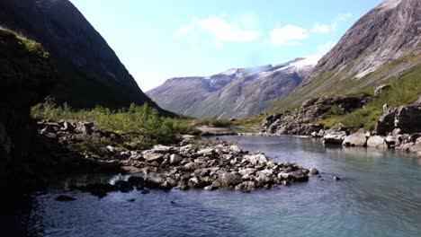 río tranquilo en noruega que conduce a una hermosa vista panorámica de un valle