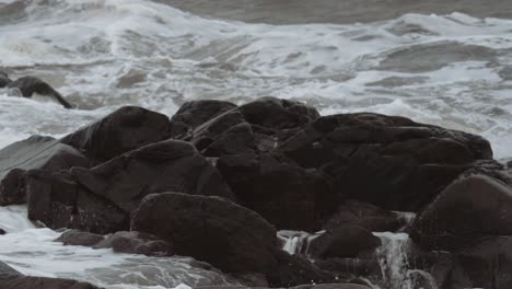 slow motion waves splash in off the unfriendly seas of canada's hudson bay and engulf the eroded rocky shore