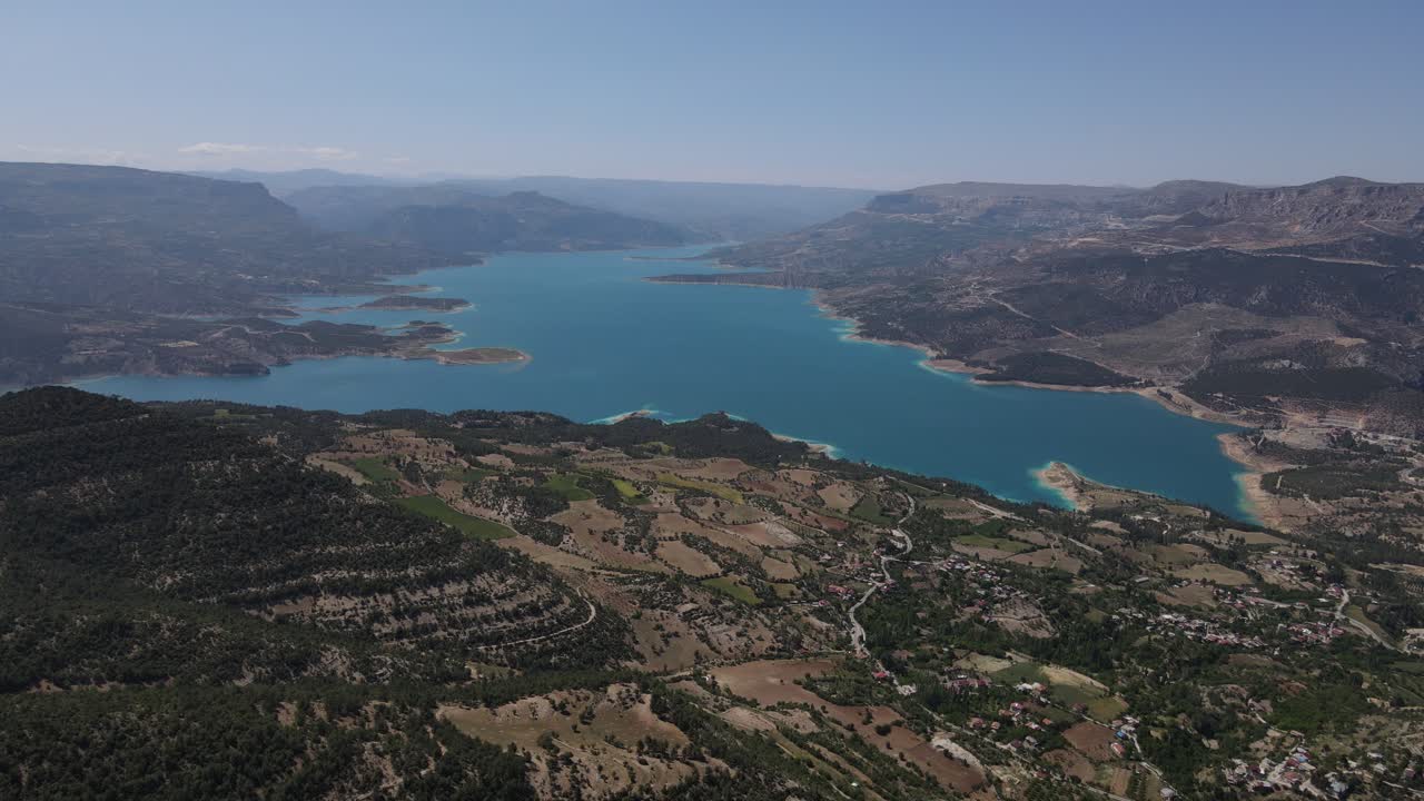 vista aerea del lago nella foresta, colline e montagne con una foresta accanto al lago, il paesaggio naturale sotto un cielo nuvoloso