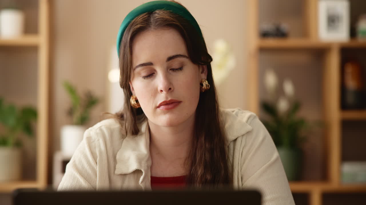 mujer concentrándose en la computadora portátil en la oficina del hogar