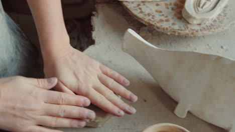 senior potter working with female trainee in workshop