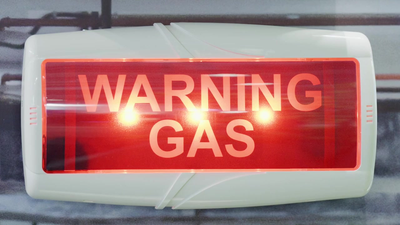 Flashing warning gas sign with red emergency lights inside industrial hydrogen laboratory during clean energy and electrolysis safety procedure