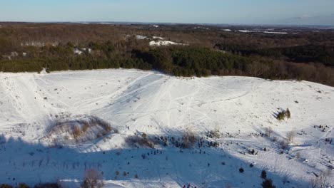 Amplia-Toma-De-Drones-Dando-Vueltas-En-Un-Parque-De-Colinas-Recreativas-Al-Aire-Libre-Cubierto-De-Nieve