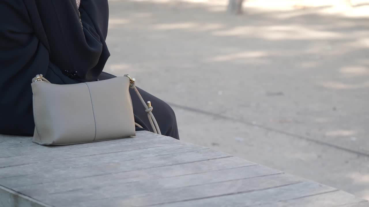 Una borsa appoggiata su una panchina di legno